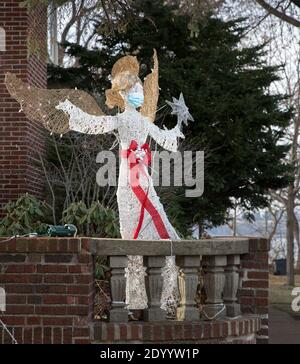 Ein Weihnachtshof Rasen Ornament eines Engels trägt ein Gesichtsmaske während der Covid 19 Pandemie von 2020 Stockfoto