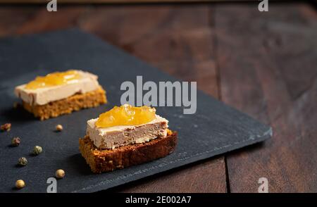 Foie Gras Toasts mit kandierten Zwiebeln und Lebkuchen auf einem Schiefer Stockfoto