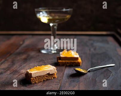 Foie Gras Toasts mit kandierten Zwiebeln und Lebkuchen und ein Ein Glas Champagner auf dem dunklen alten Hintergrund Stockfoto