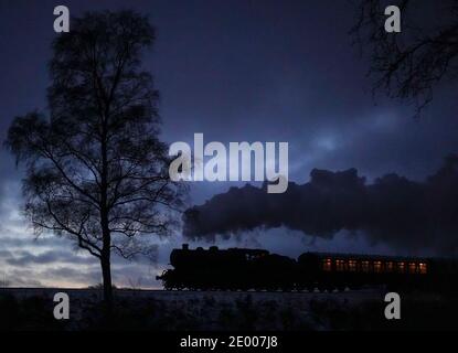 Kidderminster, Großbritannien. Dezember 2020. Trotz des erheblichen Schneefalls in der Grafschaft Worcestershire heute, nichts hält die Severn Valley Railway in ihren Spuren! Diese traditionsreiche Dampfeisenbahn hat die Passagiere den ganzen Tag über mit alten Zügen begeistert, die durch das umliegende Winterwunderland dampfen. Eine der letzten Dampfzüge des Tages ist hier zu sehen, nach Sonnenuntergang, die auf der Rückfahrt vorbeischnuppern. Kredit: Lee Hudson/Alamy Live Nachrichten Stockfoto