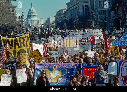 Washington, DC. USA, 26. Januar 1991 Anti-Golfkriegs-Demonstranten tragen Fahnen, Banner und Plakate, während sie die Pennsylvania Avenue hinunter zum Weißen Haus marschieren, nachdem sich die fast 100,000 Demonstranten vor dem US-Kapitol versammelt hatten Stockfoto