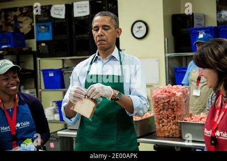 US-Präsident Barack Obama versucht, eine Plastiktüte zu schließen, während er Sandwiches mit furloughed Bundesarbeitern eintüchtigt, darunter Dolly Garcia, rechts, die im US Census Bureau arbeitet, und Chantelle Burton, links, die im Gesundheits- und Sozialministerium arbeitet, Und andere Freiwillige in einer Martha's Table Küche am 14. Oktober 2013 in Washington, DC, USA. In einer Presseerklärung forderte der Präsident den Kongress auf, den Haushaltsstaus zu beenden und den Mitarbeitern des Bundes die Rückkehr zur Arbeit zu ermöglichen. Foto von T.J. Kirkpatrick/Pool/ABACAPRESS.COM Stockfoto