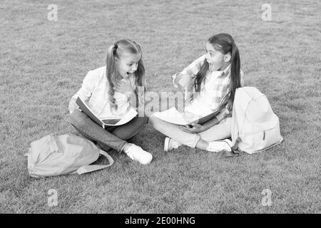 Kleine Kinder Mädchen lesen Bücher sitzen auf Gras, Wissen Tag Konzept. Stockfoto