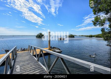 Blick auf den Steg, Ponton und einen Pelikan am Rainbow Beach, Queensland, QLD, Australien Stockfoto