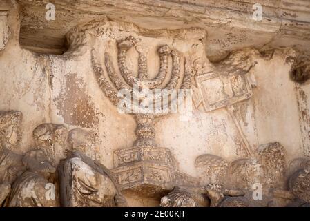 Detail der Goldenen Menora im Titusbogen, gelegen an der Via Sacra, südöstlich des Forum Romanum in Rom, Italien, das zum Gedenken an Titus Sieg in Judäa gebaut wurde, zeigt eine römische Siegesprozession mit Soldaten, die Beute aus dem Tempel, einschließlich der Menora, tragen. Die für den Bau des Kolosseums am Mittwoch, den 23. Oktober 2013 verwendet wurden. Es wurde C. 82 n. Chr. durch den römischen Kaiser Domitian kurz nach dem Tod seines älteren Bruders Titus zum Gedenken an Titus' Siege, einschließlich der Belagerung von Jerusalem im Jahre 70 n. Chr. Der Bogen soll PR haben Stockfoto