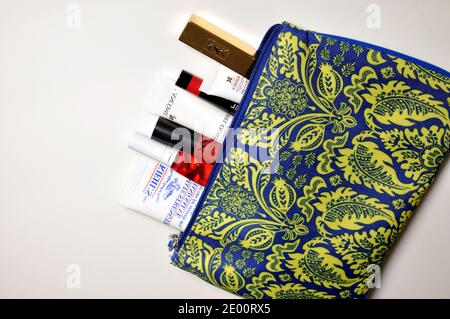 Nahaufnahme eines offenen Reise-Etui voller Kosmetik (Lippenstift, Handcreme, Gesichtscreme) Stockfoto