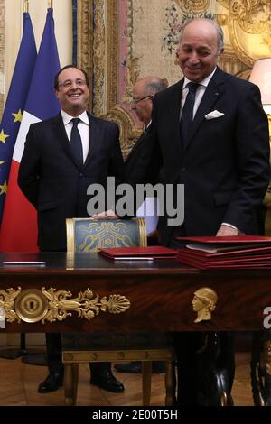 Der französische Außenminister Laurent Fabius und sein costaricanischer Amtskollege Enrique Castillo (Front-L) unterzeichnen Kooperationsabkommen während einer Zeremonie, an der der französische Präsident Francois Hollande (Back-R) und seine costaricanische Amtskollegin Laura Chinchilla (Back-L) am 4. November 2013 im Elysée-Palast in Paris teilnahmen. Foto von Stephane Lemouton/ABACAPRESS.COM Stockfoto