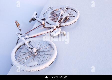 Rostig altes Fahrrad mit Schnee bedeckt Stockfoto