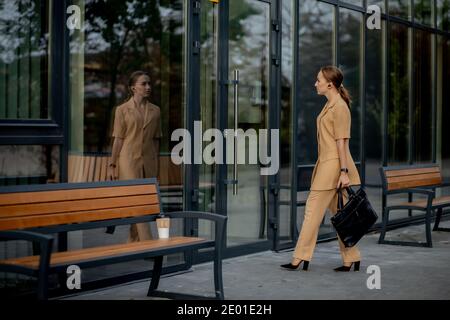 Business-Style Für Damen. Frau mit Aktenkoffer geht zur Arbeit. Porträt Von Schönen Lächelnden Frau In Stilvollen Bürokleidung. Hohe Auflösung. Stockfoto