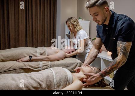 Schöne junge Frau entspannen mit ihrem Partner während der traditionellen Thai Massage im Luxus-Spa und Wellness-Center Stockfoto