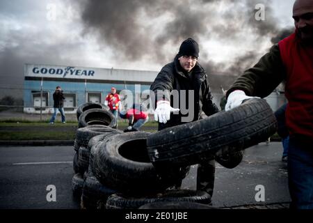 Mitarbeiter von Goodyear Tire & Rubber in Amiens North protestieren am 5. Dezember 2013 vor ihrer Fabrik in Amiens, Nordfrankreich, gegen den Stellenabbau im Unternehmen. Arbeiter von Valeo, Bridgestone, Procter & Gamble, Sanofi-Aventis oder Ricoh schlossen sich dem Kampf an und trafen sich außerhalb der Fabrik, blockiert von einem Reifenbrand. Foto von Nicolas Messyasz/ABACAPRESS.COM Stockfoto