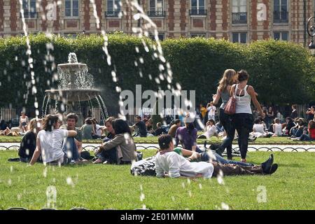 FRANKREICH / Iie-de-France/Paris/ Le Marais /Menschen Entspannen Sie sich auf dem grünen Rasen des berühmten Place des Vosges . Stockfoto