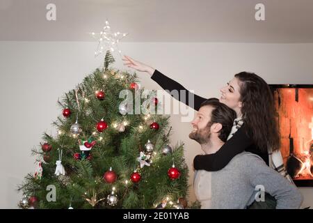 Junge glücklich paar Zeitraffer Dekoration Weihnachtsbaum. Stockfoto