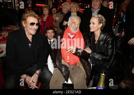 Johnny Hallyday, Laeticia Hallyday und Jean-Paul Belmondo bei der Grand Palais Funfair Party, die Marcel Campion am 19. Dezember 2013 in Paris veranstaltet hat. Foto von Jerome Domine/ABACAPRESS.COM Stockfoto