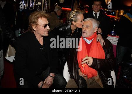Johnny Hallyday, Laeticia Hallyday und Jean-Paul Belmondo bei der Grand Palais Funfair Party, die Marcel Campion am 19. Dezember 2013 in Paris veranstaltet hat. Foto von Jerome Domine/ABACAPRESS.COM Stockfoto