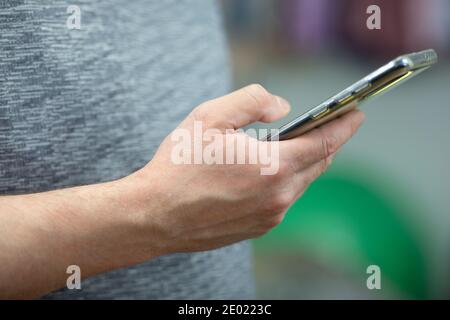 Der Mann hält das Telefon in der Hand und liest die Nachrichten aus nächster Nähe Stockfoto