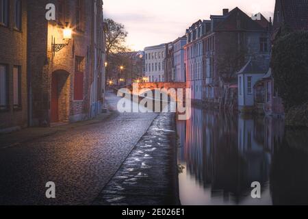 Fußspuren entlang des Gehwegs an einem ruhigen abendlichen Kanalenhang in Brügge, Belgien Stockfoto