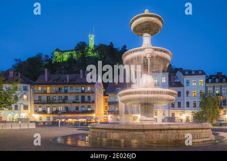 Ljubljana, Slowenien - Oktober 12 2014: Ein Springbrunnen in der Abenddämmerung im Herzen der slowenischen Hauptstadt Ljubljana, mit der Burg von Ljubljana in der pe Stockfoto