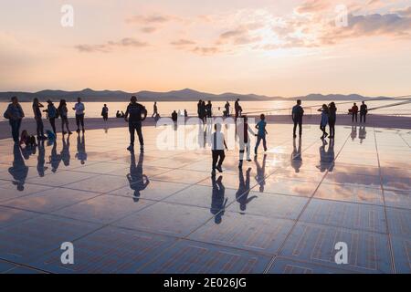 Zadar, Kroatien - 3. Oktober 2014: Touristen und Familien kommen zusammen, um den Sonnenuntergang am Monument to the Sun zu genießen, einer modernen Solaranlage, die von entworfen wurde Stockfoto