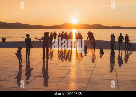 Zadar, Kroatien - 3. Oktober 2014: Touristen und Familien kommen zusammen, um den Sonnenuntergang am Monument to the Sun zu genießen, einer modernen Solaranlage, die von entworfen wurde Stockfoto