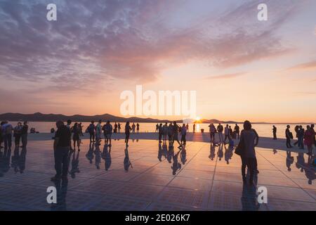 Zadar, Kroatien - 3. Oktober 2014: Touristen und Familien kommen zusammen, um den Sonnenuntergang am Monument to the Sun zu genießen, einer modernen Solaranlage, die von entworfen wurde Stockfoto