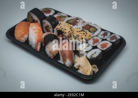 Verschiedene Arten von Sushi liegen nebeneinander auf einem Schwarze Platte Stockfoto