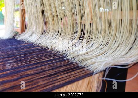Traditioneller Webstuhl mit bunten Baumwollfasern, die in die Kleidung gewebt werden. Stockfoto