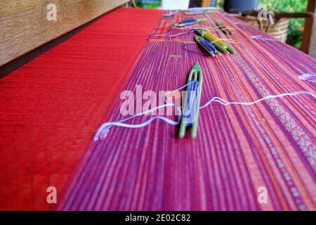 Traditioneller Webstuhl mit bunten Baumwollfasern, die in die Kleidung gewebt werden. Stockfoto