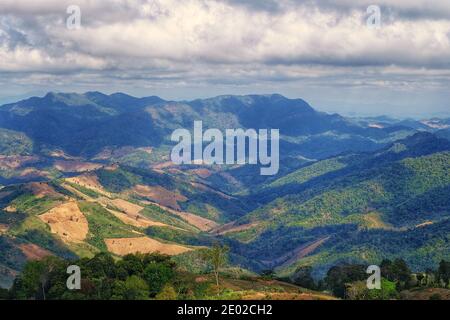 Draufsicht auf Bergkette mit Tälern und Bergen gegen einen bewölkten Himmel im Norden Thailands. Stockfoto