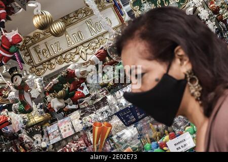 Sao Paulo, Brasilien. Dezember 2020. Eine Frau geht an einem Neujahrsdekorationsgeschäft in Sao Paulo, Brasilien, vorbei, 28. Dezember 2020. Brasilien verzeichnete am vergangenen Tag 20,548 neue COVID-19-Fälle, was die nationale Zahl auf 7,504,833 anführte, sagte das Gesundheitsministerium des Landes am Montag. Die landesweite Zahl der COVID-19-Todesopfer stieg auf 191,570, nachdem in den letzten 24 Stunden 431 weitere Todesfälle gemeldet wurden, teilte das Ministerium mit. Quelle: Rahel Patrasso/Xinhua/Alamy Live News Stockfoto