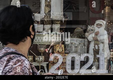 Sao Paulo, Brasilien. Dezember 2020. Eine Frau geht an einem Schaufenster vorbei, das mit einer '2021' Leuchte in Sao Paulo, Brasilien, dekoriert ist, 28. Dezember 2020. Brasilien verzeichnete am vergangenen Tag 20,548 neue COVID-19-Fälle, was die nationale Zahl auf 7,504,833 anführte, sagte das Gesundheitsministerium des Landes am Montag. Die landesweite Zahl der COVID-19-Todesopfer stieg auf 191,570, nachdem in den letzten 24 Stunden 431 weitere Todesfälle gemeldet wurden, teilte das Ministerium mit. Quelle: Rahel Patrasso/Xinhua/Alamy Live News Stockfoto