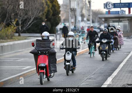 Peking, China. Dezember 2020. Menschen reiten auf der Straße in der Nähe von Xuanwumen im Xicheng Bezirk von Peking, Hauptstadt von China, 29. Dezember 2020. Eine kalte Welle brachte Stürme nach Peking am Dienstag. Quelle: Li Xin/Xinhua/Alamy Live News Stockfoto