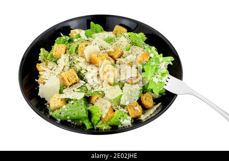 Klassischer Caesar-Salat mit Rosensalat und Parmesenkäse Serviert in einem schwarzen Gericht isoliert auf weißem Hintergrund Stockfoto
