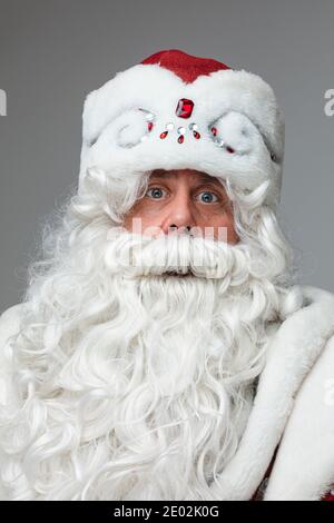 Weihnachten und Neujahr Studio-Porträt von grauhaarigen Bärte überrascht Männlich auf grauem Studiohintergrund Stockfoto