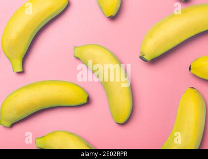 Bananen auf farbigem Hintergrund. Muster von gelben frischen Bananen auf einem reinen rosa Hintergrund. Minimales und kreatives Konzept. Stockfoto