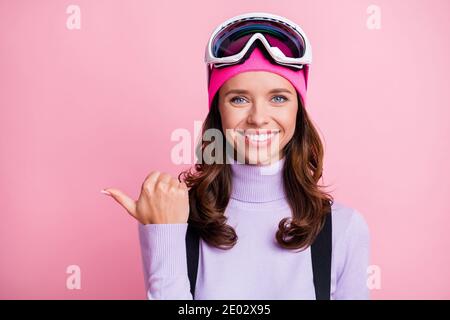 Foto-Porträt einer lächelnden Frau mit dem Daumen auf leere Stelle zeigen Isoliert auf pastellrosa Hintergrund Stockfoto