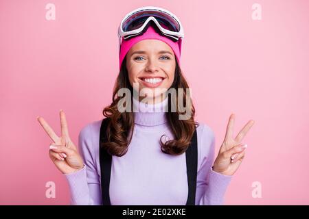 Foto-Porträt von aufgeregt Frau zeigt zwei V-Zeichen isoliert auf Pastellrosa Hintergrund Stockfoto