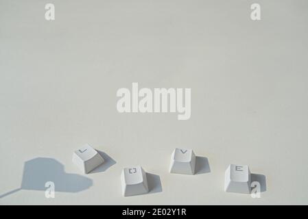 Liebeswort bestehend aus Tastaturtasten, herzförmiger Schatten auf grauem Hintergrund Stockfoto