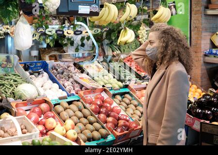 Frau tragen Gesichtsmaske kauft frisches Obst und Gemüse Auf einem Bauernmarkt in Sevilla Stockfoto