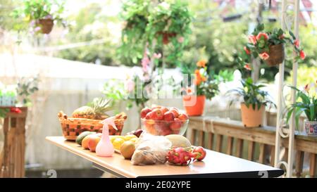 Vorbereitet verschiedene Früchte während der Selbstisolation zu Hause. Vitamine stärken die Immunität. Äpfel, Pitaya, Kiwi, Cantaloupe und Mango auf dem Tisch. Home Balkon pl Stockfoto