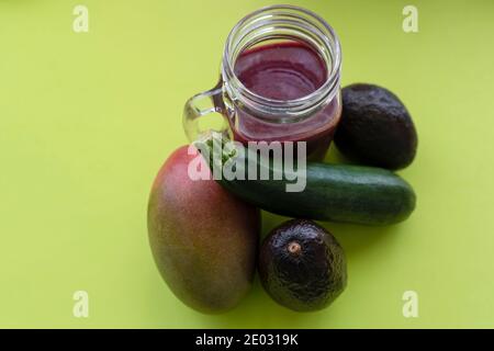 Roter Smoothie mit Mango, Avocados und Zucchini auf grünem Hintergrund.gesundes Superfood und Detox-Drink-Konzept mit Kopierraum. Stockfoto