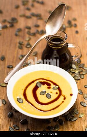Kürbiscreme mit Löffel und Samenöl Stockfoto
