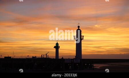 Dock von Trouville-sur-Mer, Normandie, Frankreich bei Sonnenuntergang; orangefarbener Himmel und Leuchttürme Stockfoto