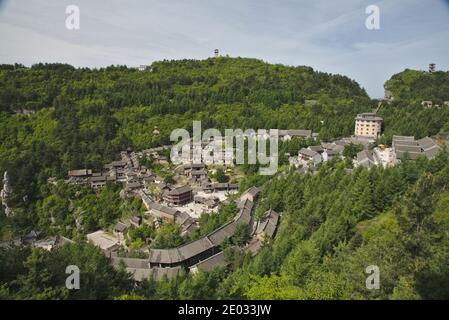 Ein altes Dorf in grünen Bergen in China; Häuser umgeben von Wald Stockfoto