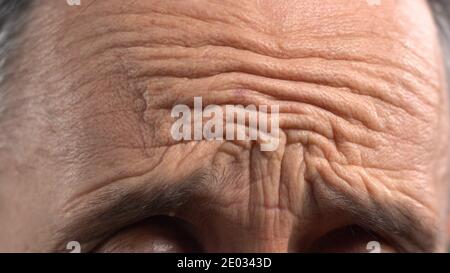 Faltige Männliche Stirn Nahaufnahme. Stirn und Falten des reifen Mannes Stockfoto