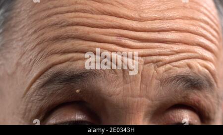 Faltige Männliche Stirn Nahaufnahme. Stirn und Falten des reifen Mannes Stockfoto