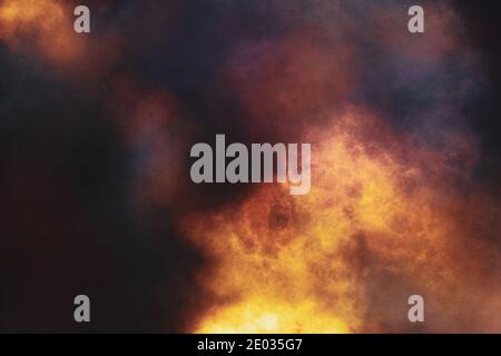 Abstrakte Illustration. Flamme und Feuer brennen in dunkler und schwarzer Nacht. Rauch und Wolken. Ein Teil des Bildes ist unscharf. Stockfoto