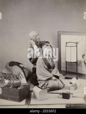 Vintage-Portraitfoto aus dem 19. Jahrhundert, bei dem eine junge Japanerin von einem blinden Masseur massiert wird, anma, Japan. Stockfoto