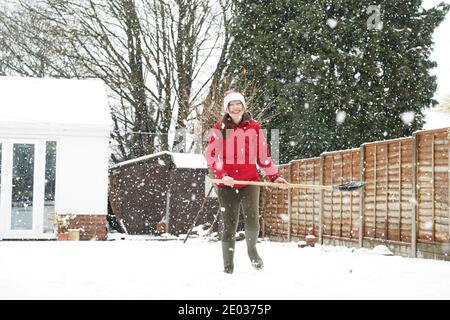 Kidderminster, Großbritannien. Dezember 2020. Wetter in Großbritannien: Während immer mehr Schnee über Worcestershire fällt, weiß diese Frau, wann sie geschlagen wird und gibt fröhlich auf, den Schnee in ihrem Kidderminster Garten zu räumen, um die Wärme im Inneren zu spüren! Kredit: Lee Hudson/Alamy Live Nachrichten Stockfoto