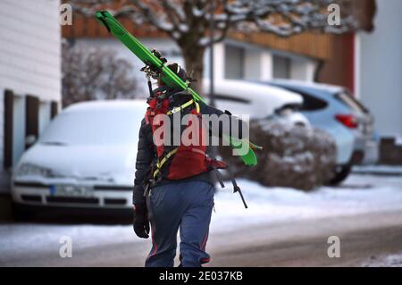 Nesselwang, Deutschland. Dezember 2020. Ein Tourenskifahrer geht mit geschulterten Skiern in Richtung Berg. Quelle: Karl-Josef Hildenbrand/dpa/Alamy Live News Stockfoto